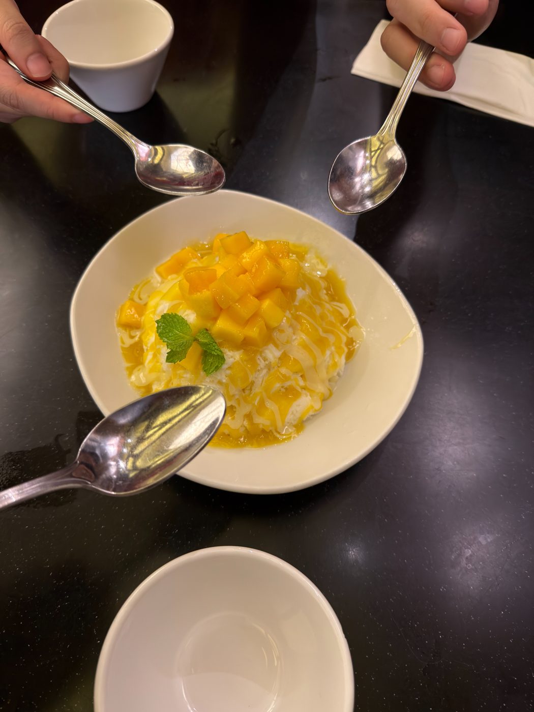 Friends sharing mango shaved snow at Din Tai Fung